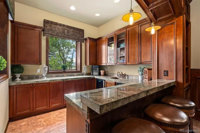 a kitchen with stainless steel appliances granite countertop a sink a stove and a wooden cabinets