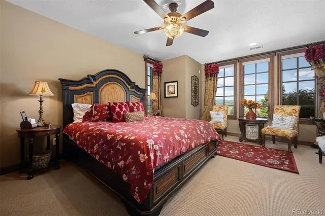 a spacious bedroom with a bed a couch and a large window