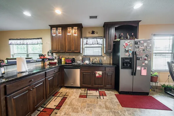 a kitchen with stainless steel appliances granite countertop a refrigerator stove and sink
