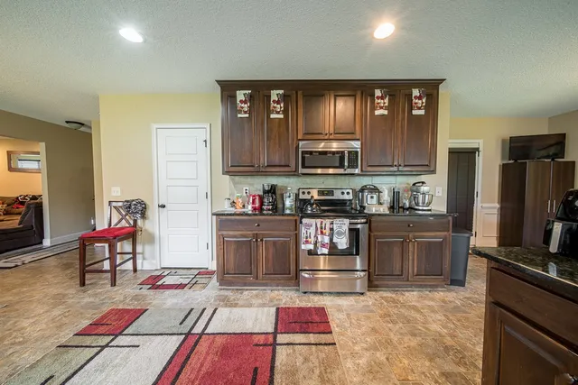 a kitchen with a refrigerator and a stove top oven