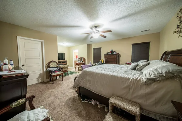 a bedroom with a bed gym equipment and a desk
