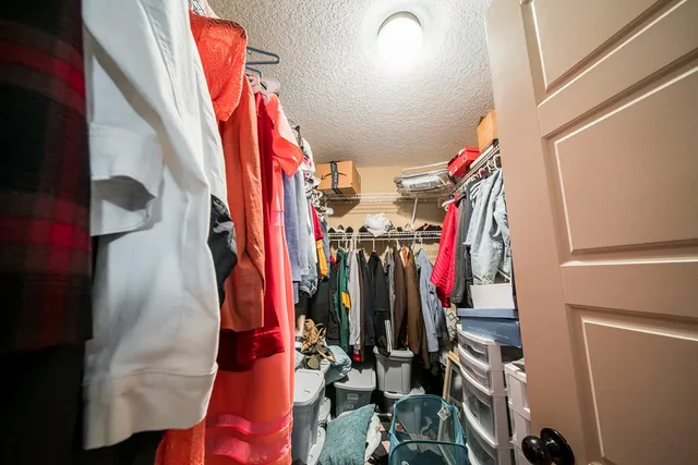 a view of walk in closet with clothes
