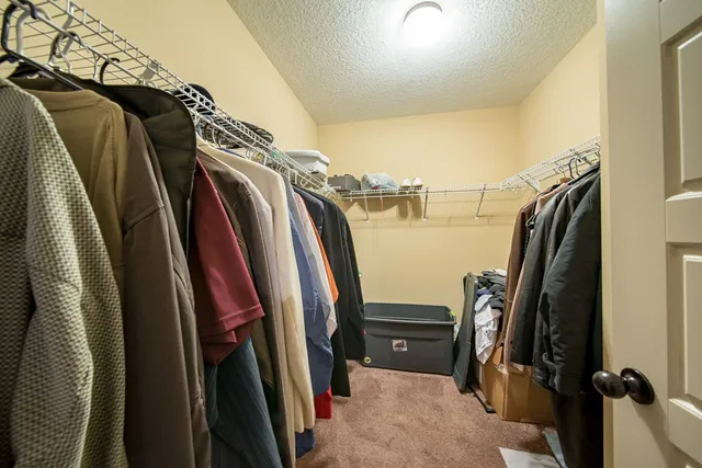 a view of walk in closet with clothes and shoes