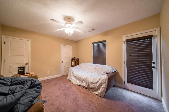 a spacious bedroom with a bed and a chandelier