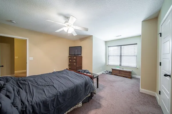 a bedroom with a bed and dresser with mirror