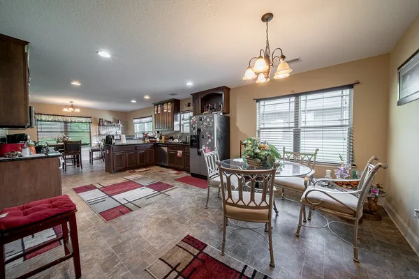 a outdoor dining room with furniture a chandelier and wooden floor