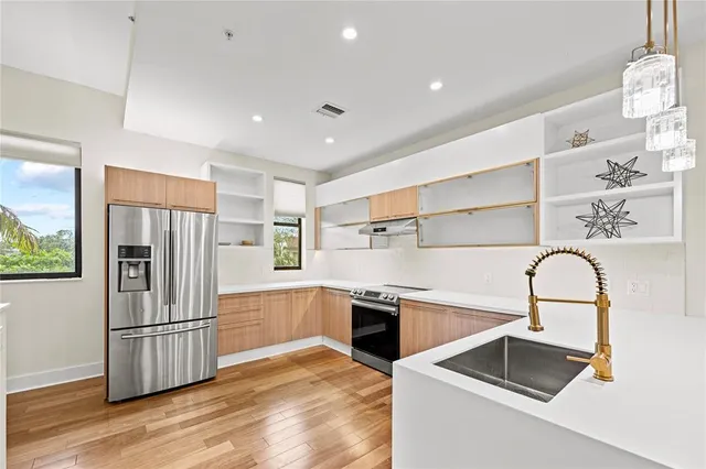 a kitchen with stainless steel appliances granite countertop a refrigerator and a sink