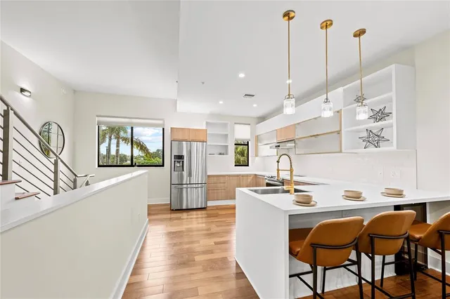 a kitchen with stainless steel appliances kitchen island granite countertop a sink a stove and a refrigerator