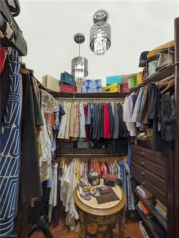 a view of walk in closet with clothes and shoes