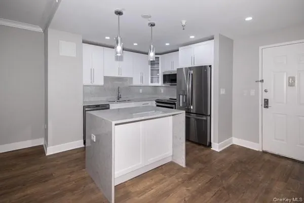 a kitchen that has a refrigerator a stove and a wooden floor