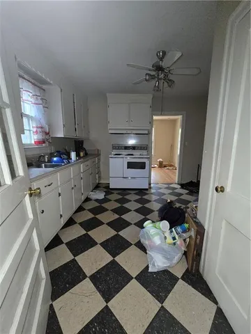 a kitchen with a checkered floor and white cabinets