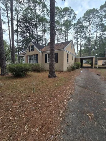 a view of a house with a tree in front of it