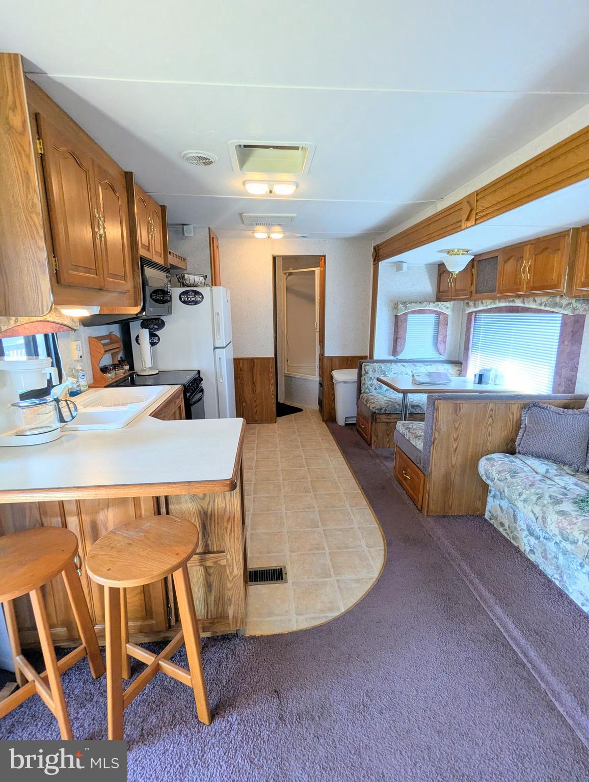 8 Avalanche Avenue Falling Waters, WV 25419 - Photo 6 of 13 a living room with stainless steel appliances furniture a rug and a kitchen view