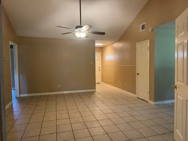 an empty room with closet and a chandelier fan