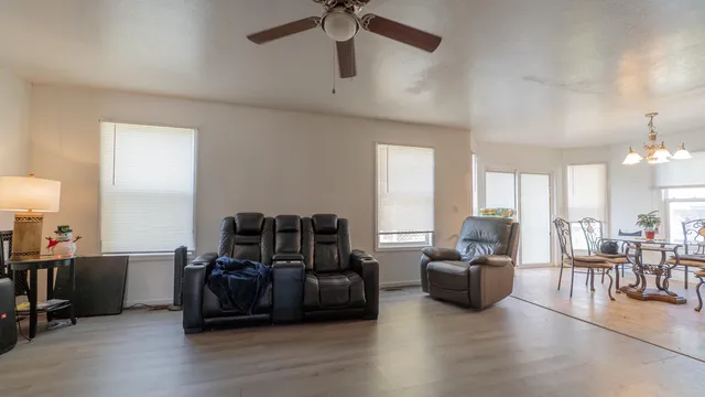 a view of a livingroom with furniture a ceiling fan and wooden floor