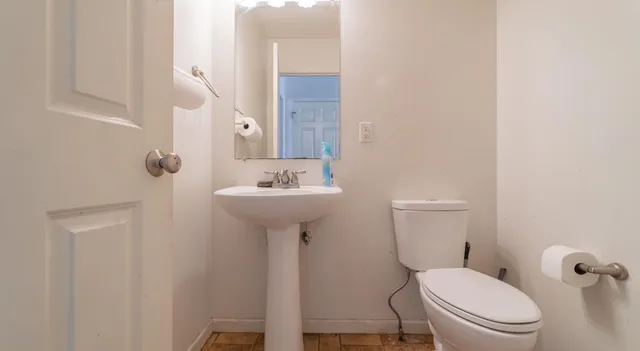 a bathroom with a sink toilet and a mirror