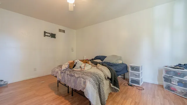 a room with a bed and wooden floor