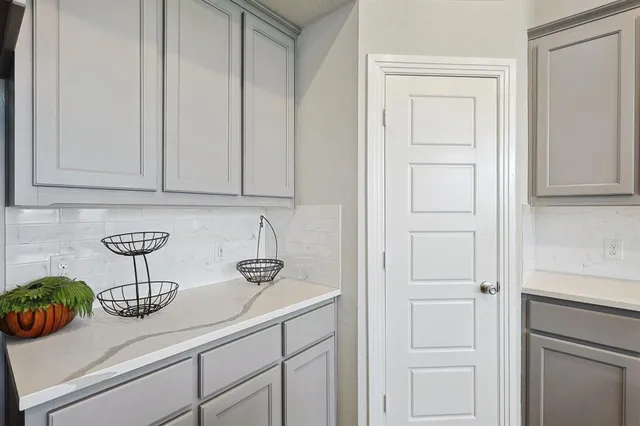 a view of kitchen with white cabinets