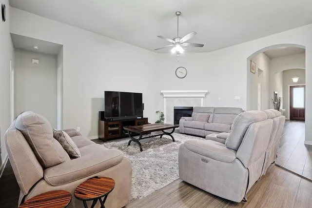 a living room with furniture a fireplace and a flat screen tv