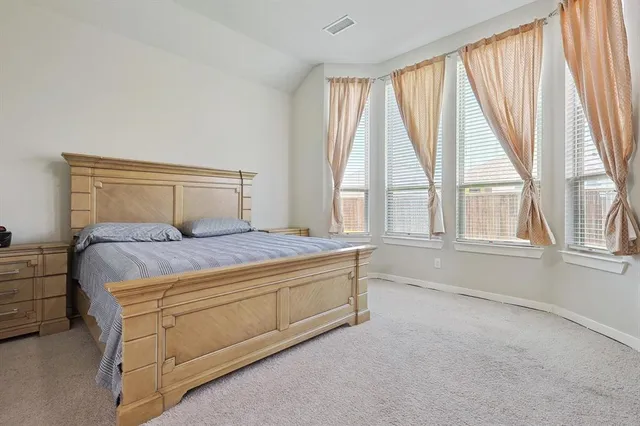 a bedroom with a bed and a large window