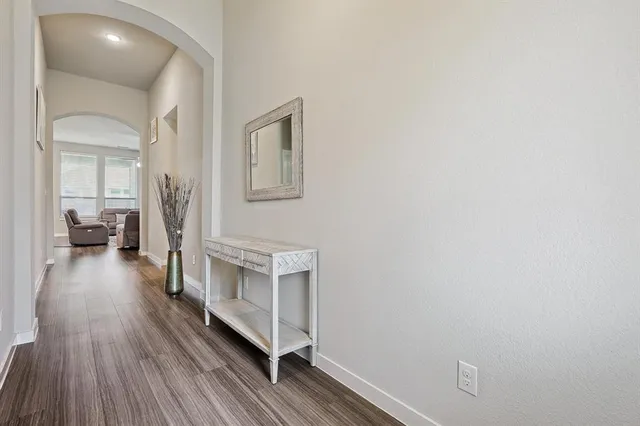 a hallway with wooden floor and furniture