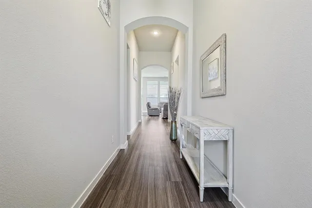 a view of a hallway with wooden floor and staircase