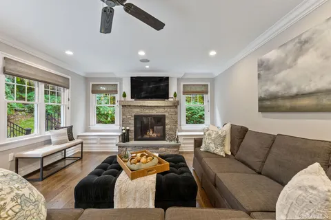 a living room with furniture fireplace and a large window