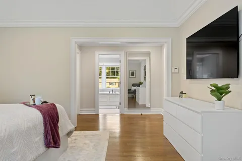 a spacious bedroom with a bed and a flat screen tv