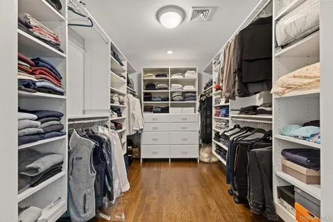 a view of walk in closet with clothes and shoes