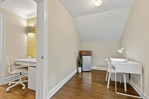 a view of a workspace with furniture and wooden floor