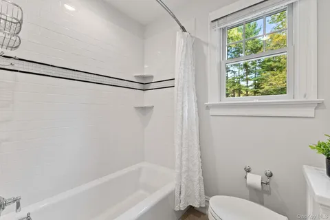 a bath room with a toilet and a bath tub