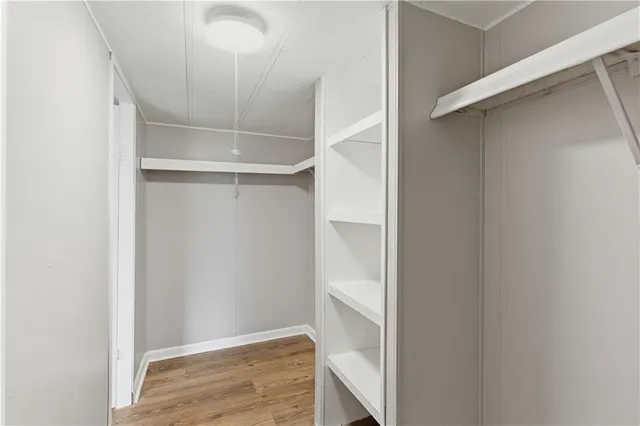a view of walk in closet with empty racks