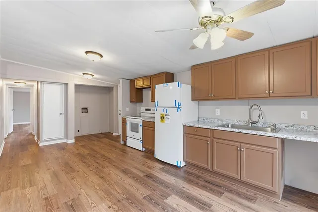 a kitchen with stainless steel appliances granite countertop a sink cabinets and wooden floor