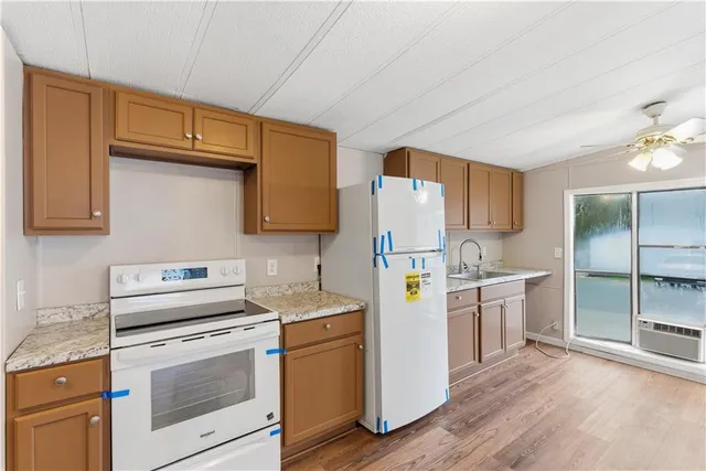 a kitchen with a sink cabinets stainless steel appliances and wooden floor