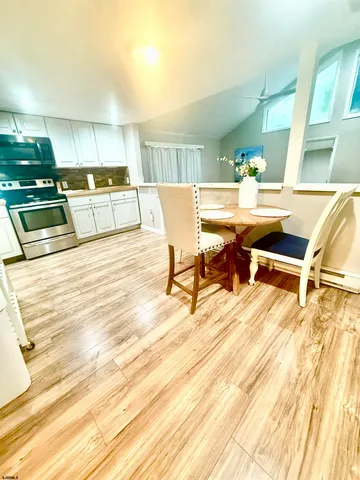 a living room with stainless steel appliances kitchen island granite countertop a sink and cabinets