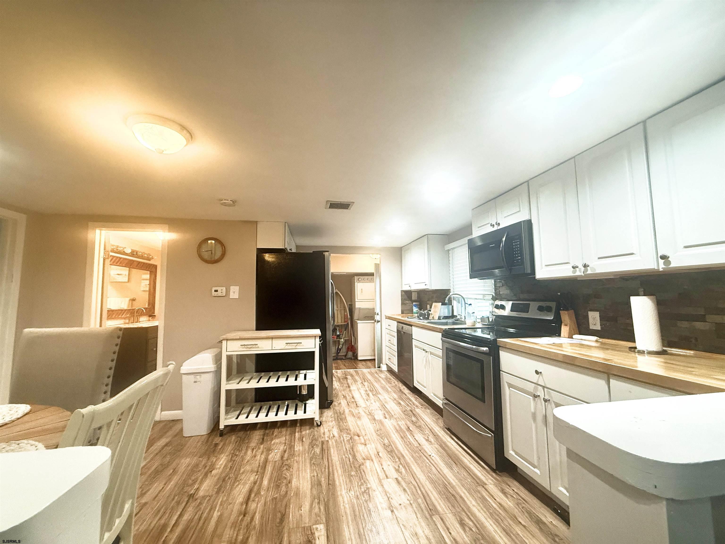 752 7th Street, Unit B Somers Point, NJ 08244 - Photo 2 of 10 a kitchen with stainless steel appliances a stove top oven a sink a dining table and chairs