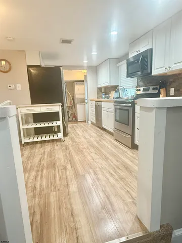 a view of kitchen with microwave and cabinets