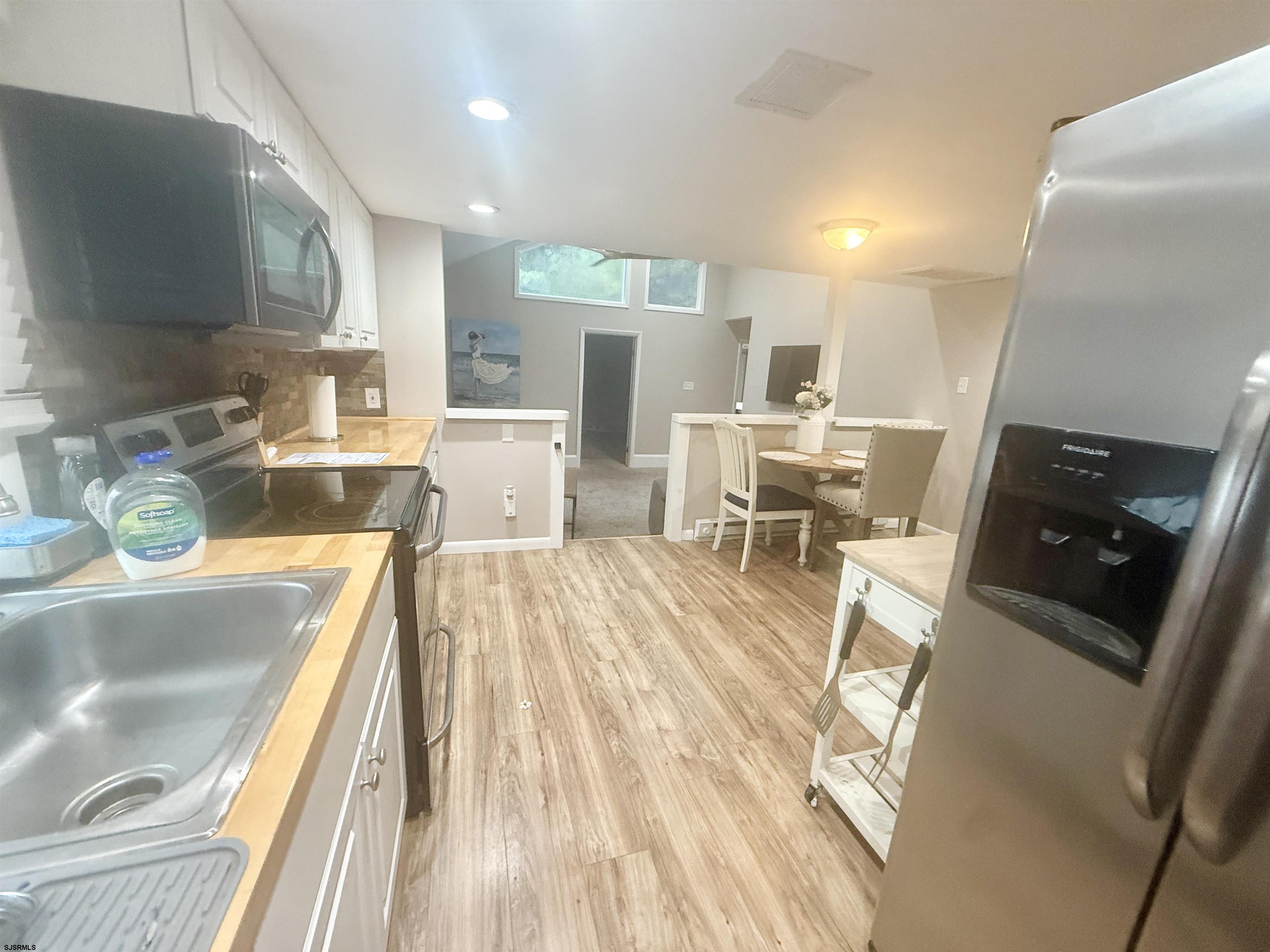 752 7th Street, Unit B Somers Point, NJ 08244 - Photo 4 of 10 a living room with stainless steel appliances furniture a rug kitchen view and a table