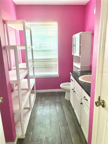 a bathroom with a sink vanity mirror bathtub and toilet