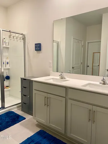 a bathroom with a double vanity sink and a mirror