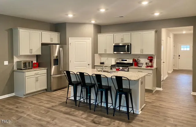 a kitchen that has a lot of cabinets in it and appliances
