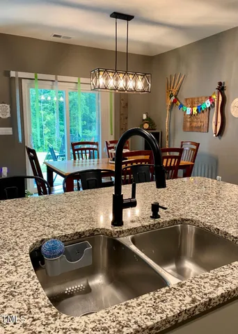 a kitchen with a sink a counter top space a stove and cabinets