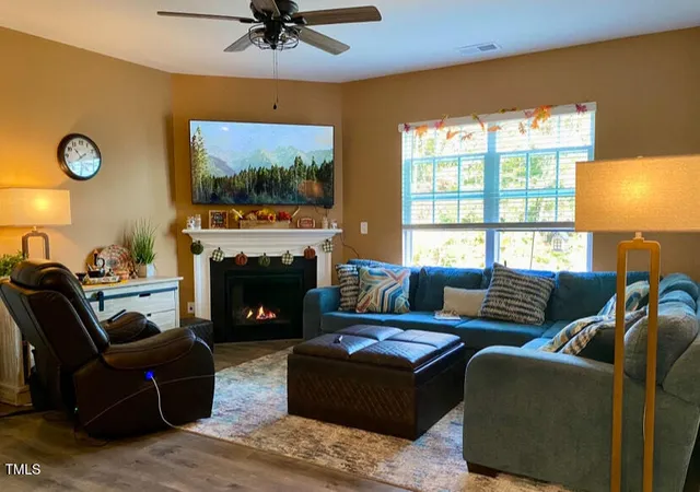 a living room with furniture a fireplace and a flat screen tv