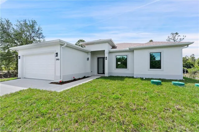 a view of an house with backyard space and garage