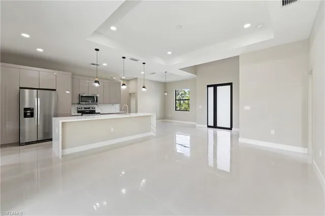 a large white kitchen with refrigerator a sink and a dishwasher
