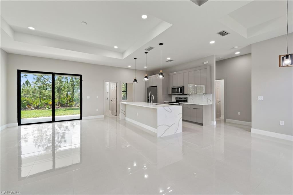 2903 37th Street West Lehigh Acres, FL 33971 - Photo 7 of 23 a view of a kitchen with kitchen island a large counter top space and stainless steel appliances