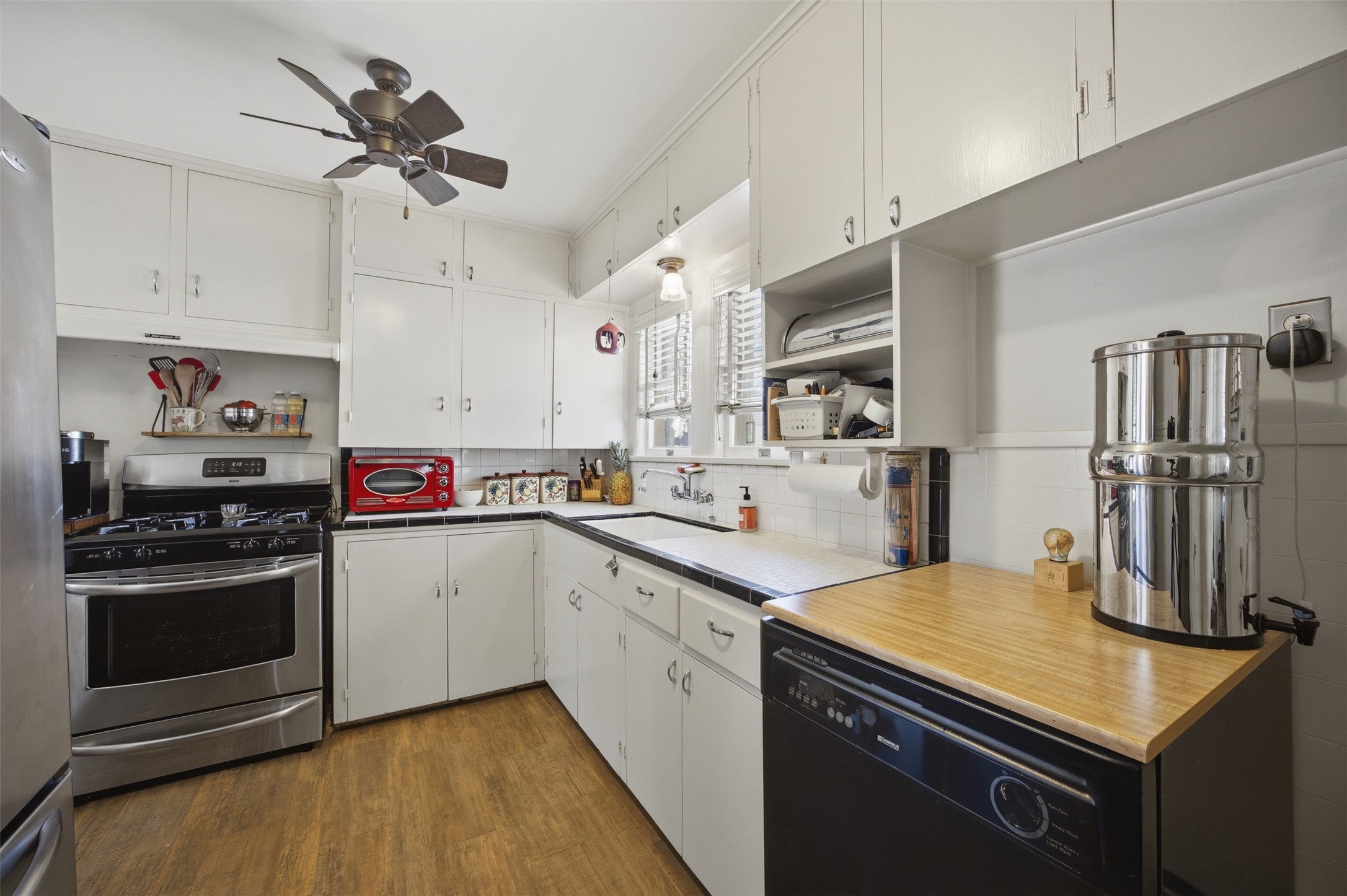 1030 East 44th Street Austin, TX 78751 - Photo 11 of 29 a kitchen with a sink stainless steel appliances and white cabinets