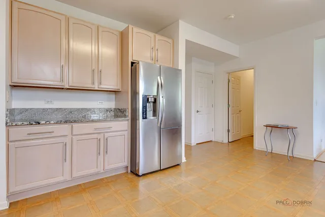 a kitchen with a refrigerator sink and cabinets