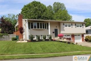65 Wilk Road Edison, NJ 08837 - Photo 2 of 17 a front view of a house with a garden and trees