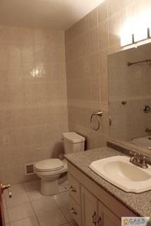 65 Wilk Road Edison, NJ 08837 - Photo 14 of 17 a bathroom with a granite countertop toilet and a sink